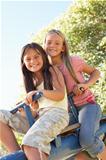 Two Girls Riding On See Saw In Playground