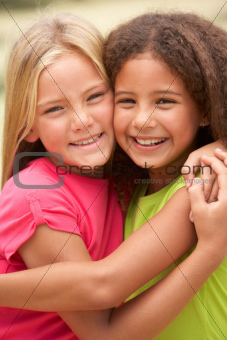 Two Girls In Park Giving Each Other Hug