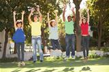 Group Of Teenagers Jumping In Air In Park