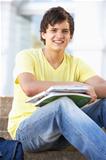 Male Teenage Student Sitting Outside On College Steps