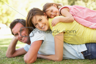 Young Family Relaxing In Park