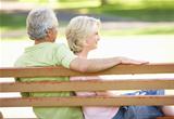 Senior Couple Sitting Together On Park Bench