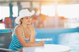 Portrait of dreaming woman at pool bar looking on copy space