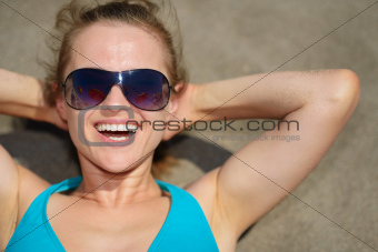 Portrait of woman laying on sand beach