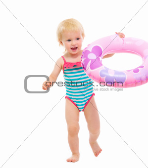 Baby in swimsuit playing with inflatable ring