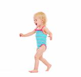 Happy baby in swimsuit running on white