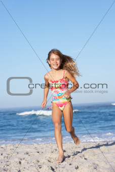 Young Girl Running Along Sandy Beach