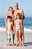Grandparents And Grandchildren Standing On Sandy Beach