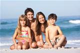 Young Family Relaxing On Beach Holiday