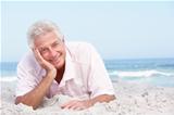 Senior Man Relaxing On Sandy Beach