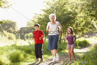 Grandmother Jogging In Park With Grandchildren
