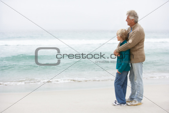 Grandfather And Son Standing On Winter Beach Together