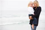 Mother And Daughter On Holiday Standing On Winter Beach