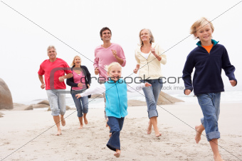 Three Generation Family Running Along Winter Beach Together