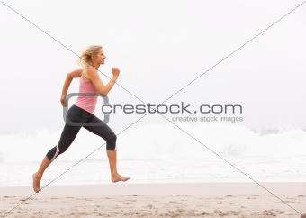 Young Woman Running Along Winter Beach
