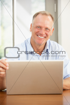 Middle Aged Man Using Laptop At Home