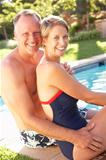 Couple Relaxing By Pool In Garden