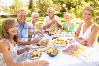 Extended Family Enjoying Meal In Garden