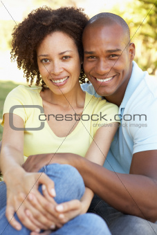 Portrait Of Young Couple Sitting In Park