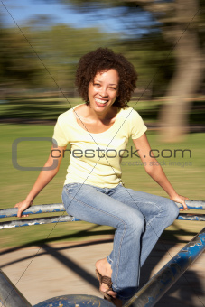 Young Woman Riding On Roundabout In Park