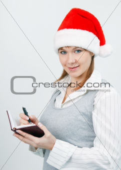 woman with a notebook in a Christmas hat