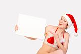 Christmas girl holding up a white sign for copyspace