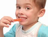 The boy eats fruit candy on a white background