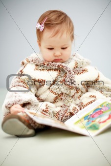 Small baby reading a book