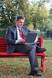 Businessman with laptop outside