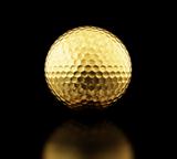 gold golf ball on black background