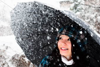 Young woman with umbrella in a blizzard