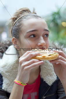 Teenage girl eating sandwich