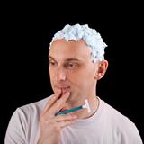 Shave or not to shave - young man with light blue shaving foam o