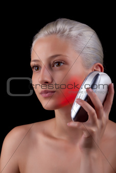 Young woman getting photo-therapy treatment with red light 