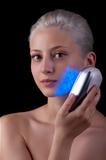 Young woman getting photo-therapy treatment with blue light 