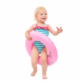 Happy baby in swimsuit with inflatable ring