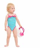 Cute baby in swimsuit with handbag looking on copy space