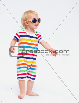 Smiling baby in swimsuit and sunglasses looking on copy space