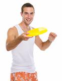 Happy young man playing with flying disc