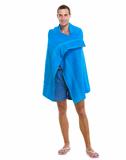 Happy young man wrapped in blue beach towel