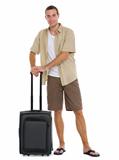 Happy tourist with wheels bag ready to vacation