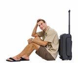 Happy tourist sitting near wheels bag and dreaming about vacation