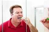 Man Brushing His Teeth in Bathroom