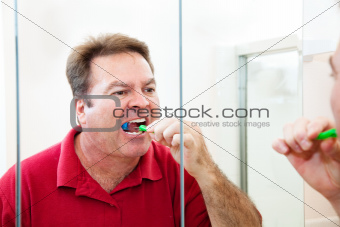 Man Brushing His Teeth in Bathroom
