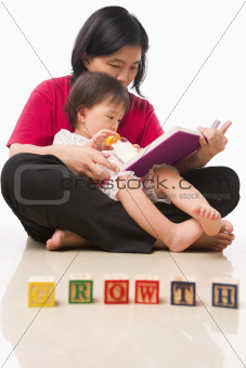 Mother and her little girl reading book
