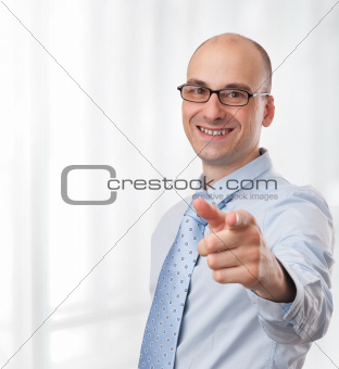 smiling young businessman pointing finger at camera