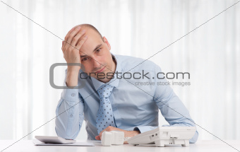 Stressed businessman sitting at workplace