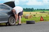Man changing tire on the road