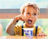Little Boy Is Eating Yogurt.