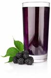 ripe blackberry with green leaf and juice in glass